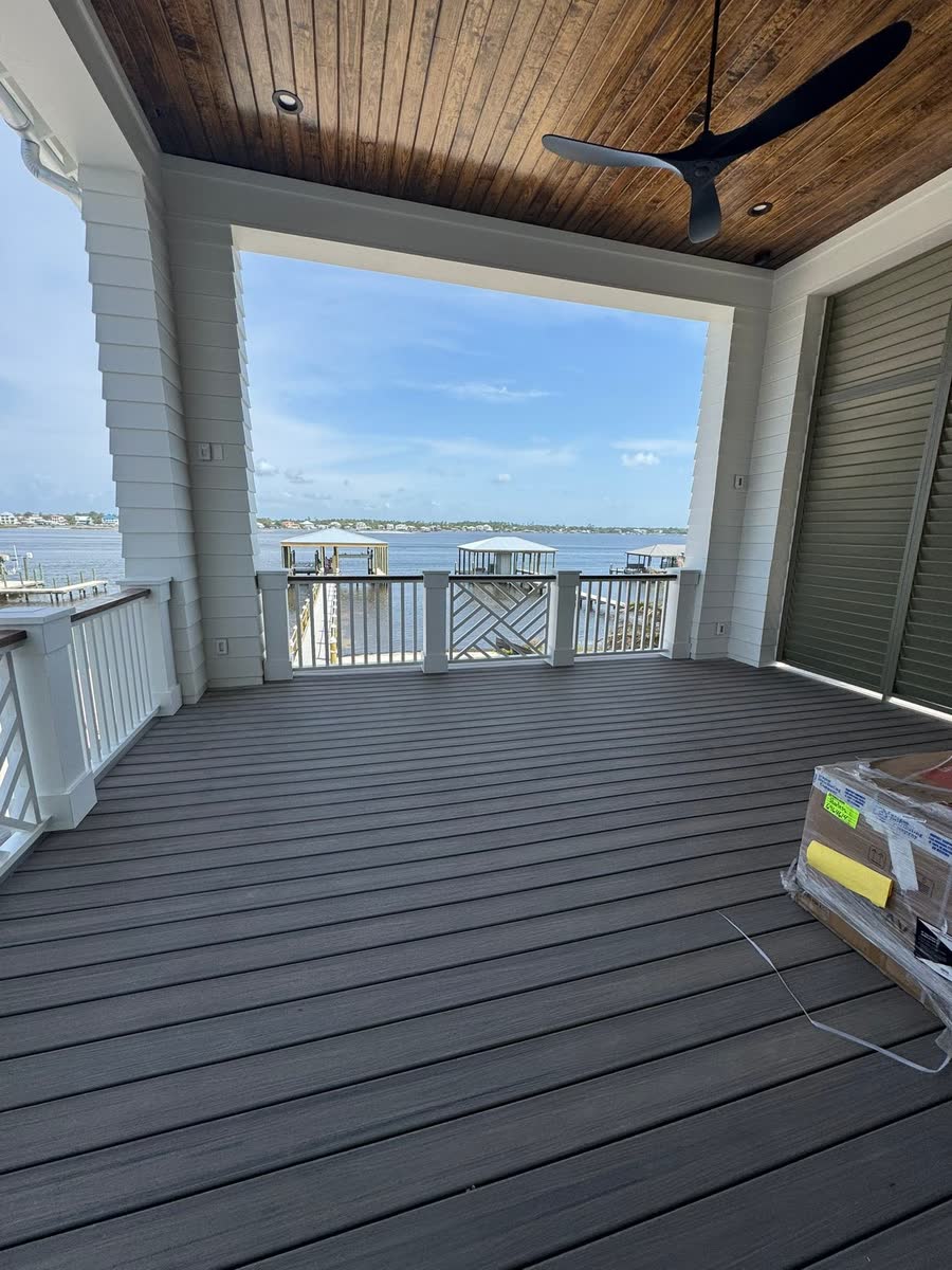 A covered porch with a wood-planked ceiling looking out over the water.