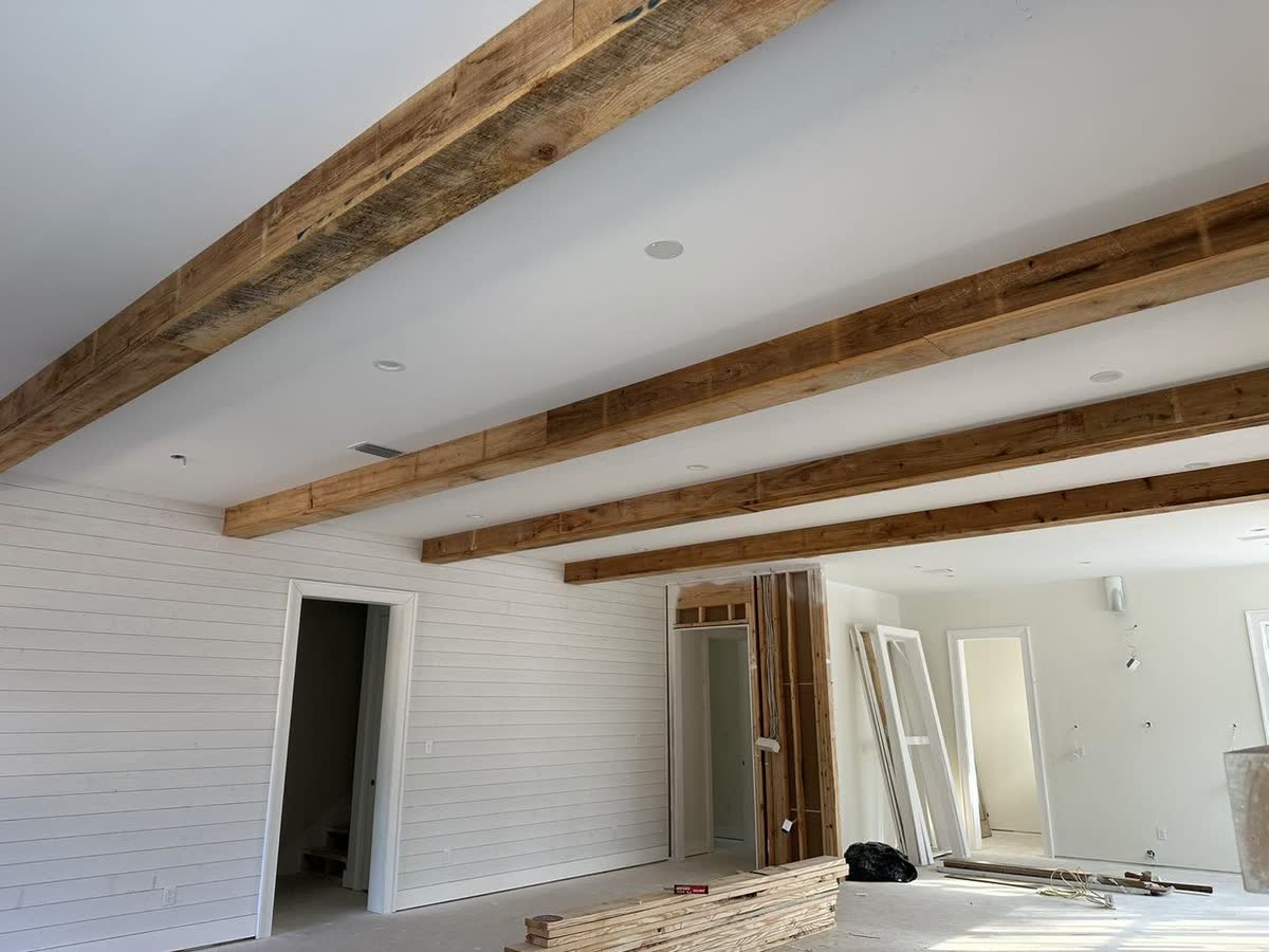 Rough wood beams across a white vaulted ceiling.