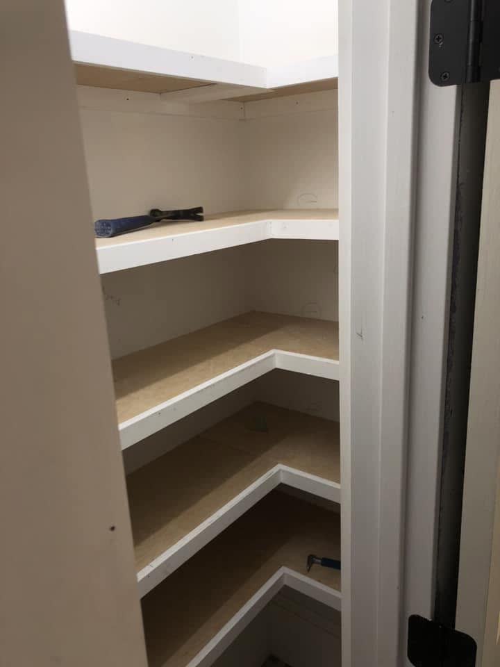 Curved built-in corner shelves in white.