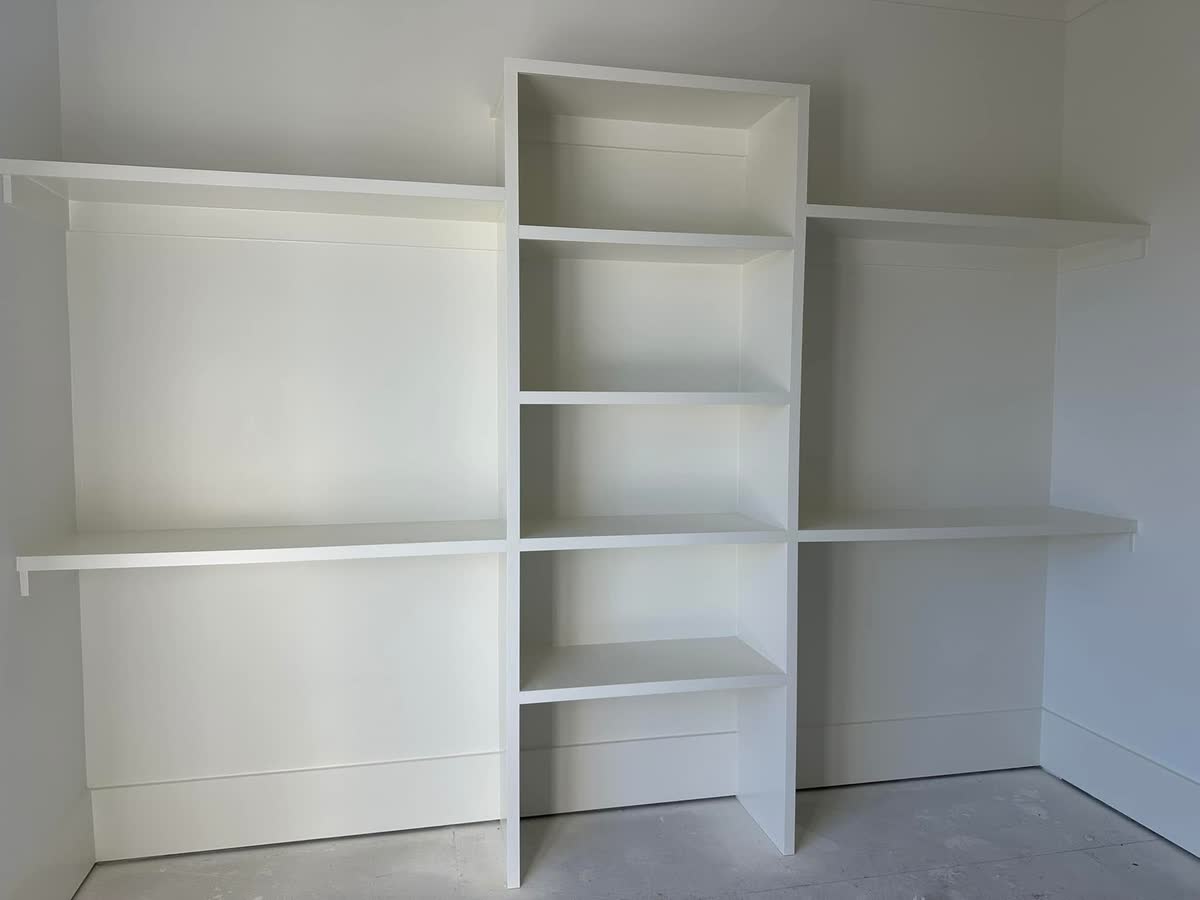 Built-in white shelves along a bedroom wall.